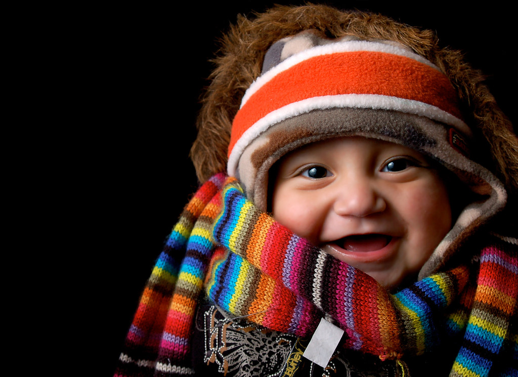 A young child bundled in a scarf and hat outdoors on a cold winter day